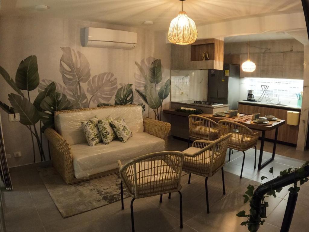 a living room with a couch and chairs and a kitchen at Casa Yireth in Ricaurte
