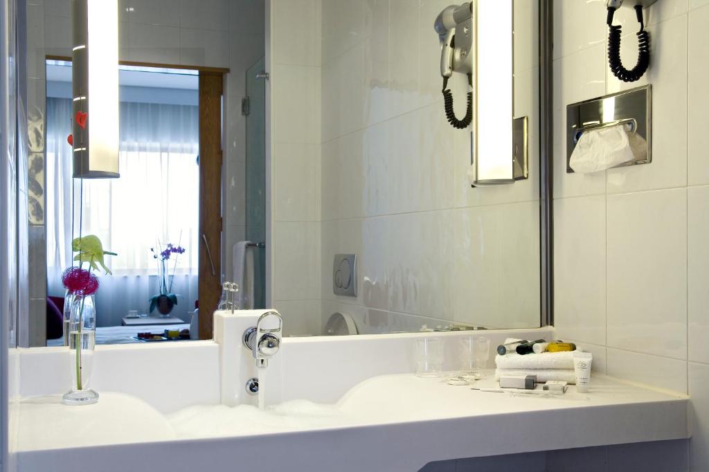 a bathroom with a sink and a mirror at Novotel Porto Gaia in Vila Nova de Gaia
