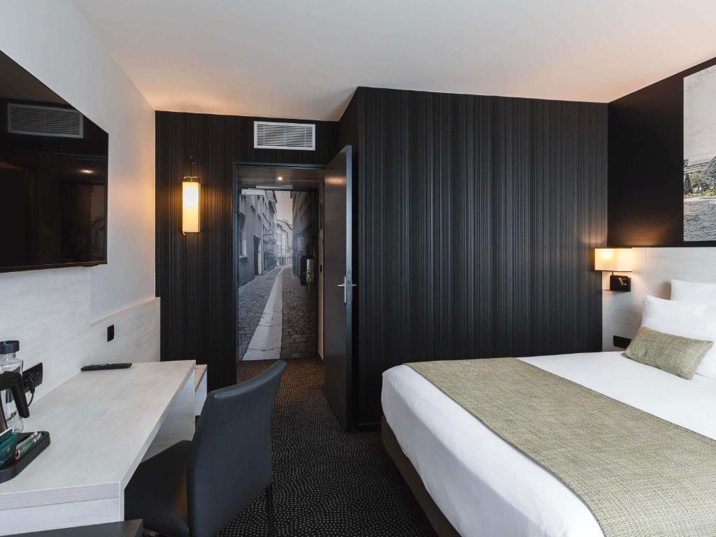 a hotel room with a bed and a desk at Hôtel Mercure Lyon Centre Charpennes Parc de la Tête d'Or in Villeurbanne