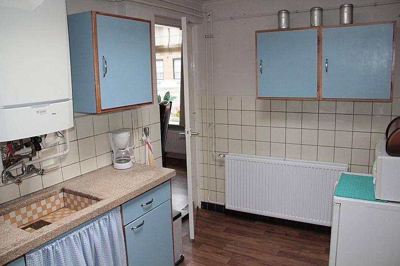 een keuken met blauwe kasten en een aanrecht bij Vakantiehuisje in Centrum Ootmarsum in Ootmarsum