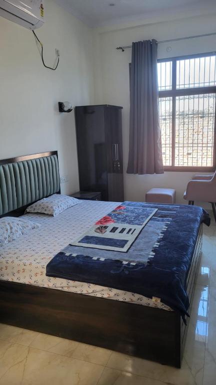 a bedroom with a bed with a blue blanket on it at Shivganga viila in Varanasi