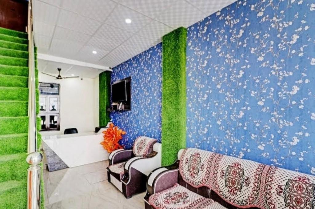 a waiting room with a blue and green wall at Gold Hotel in Faridabad