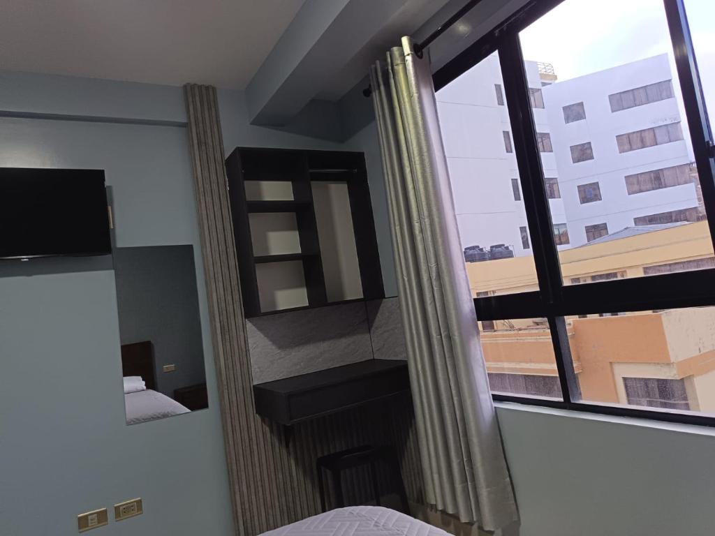 a room with a bed and a window with a view at Hotel Virgen de las Peñas 2 in Oruro