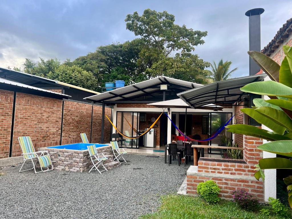 a patio with chairs and a table and a swing at Cabaña El Anhelo Tradición in Ginebra