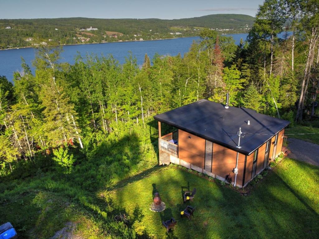 an overhead view of a cabin in the woods with a lake at L'Enchanteur - Private Spa & Pet Friendly in Pohénégamook
