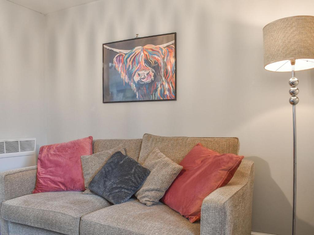 a living room with a couch with pillows and a painting at Corner Spot in Hednesford
