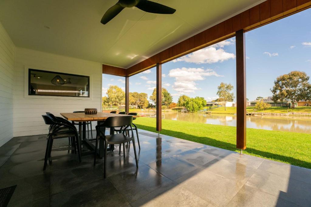 a dining room with a table and chairs and a large window at 10 Jefferson Court in Wellington East