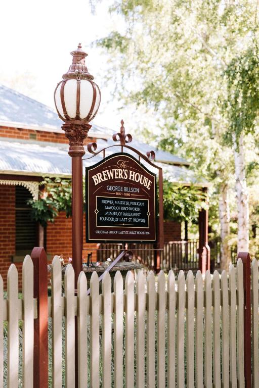 a sign in front of a fence and a street light at The Brewers House in Beechworth