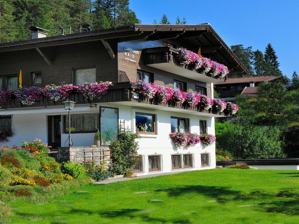 dom z skrzyniami kwiatowymi na balkonie w obiekcie Landhaus Haid w mieście Seefeld in Tirol