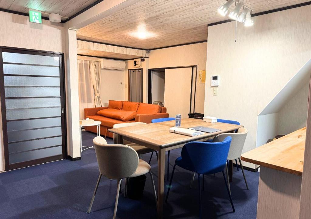 a room with a table and chairs and a couch at Nishijin Stay One in Fukuoka