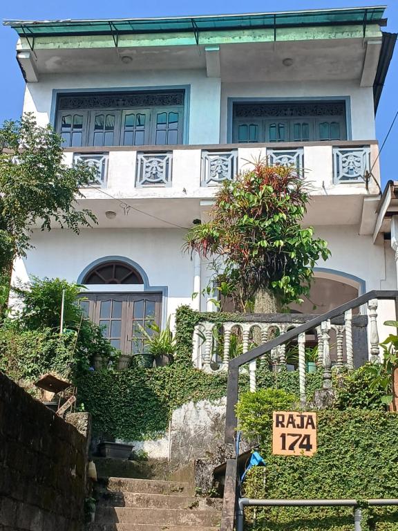 a white house with stairs in front of it at Raja174 Homestay in Kandy