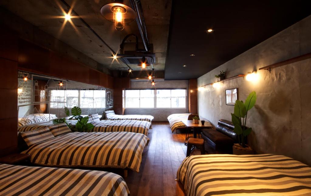 a row of beds in a room with windows at Guest House Re-worth Yabacho1 1F in Nagoya