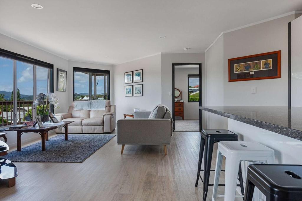 a living room with a couch and a table at Cable Bay Serenity in Cable Bay