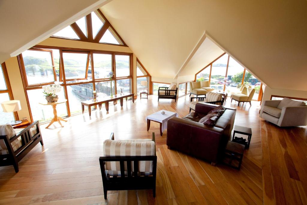 una gran sala de estar con muebles y ventanas grandes. en Inishbofin House Hotel, en Inishbofin