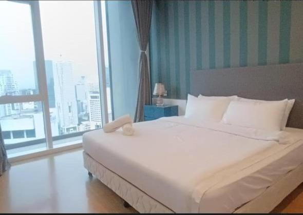 a bedroom with a white bed with a large window at Platinum Face suits in Kuala Lumpur
