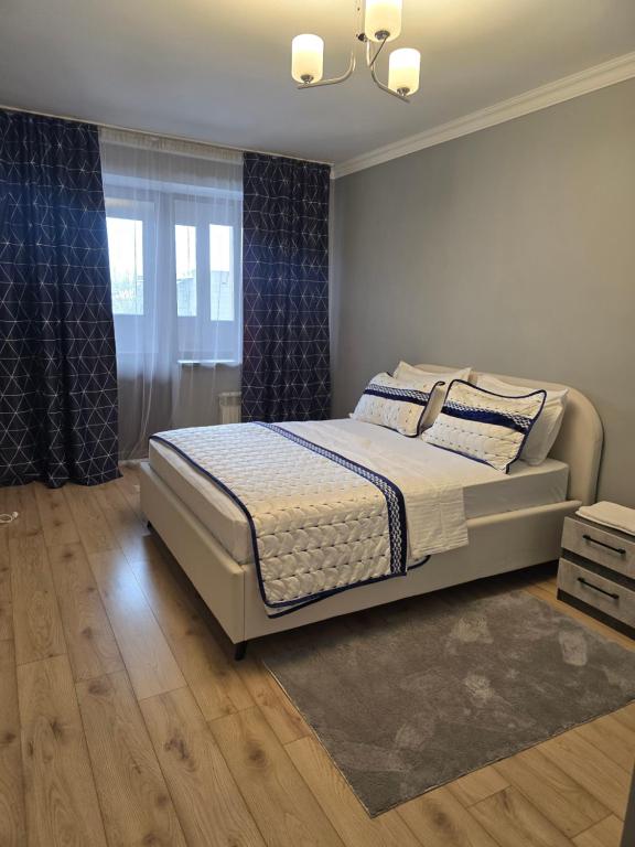 a bedroom with a bed and a window at Алматушечка in Almaty