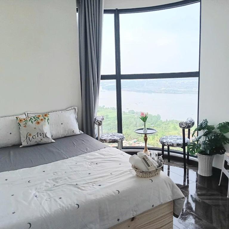 a bedroom with a bed and a large window at GÂY THƯƠNG NHỚ Homestay Phòng trong vinhome grand park tên cũ I love vinhome grand park in Gò Công