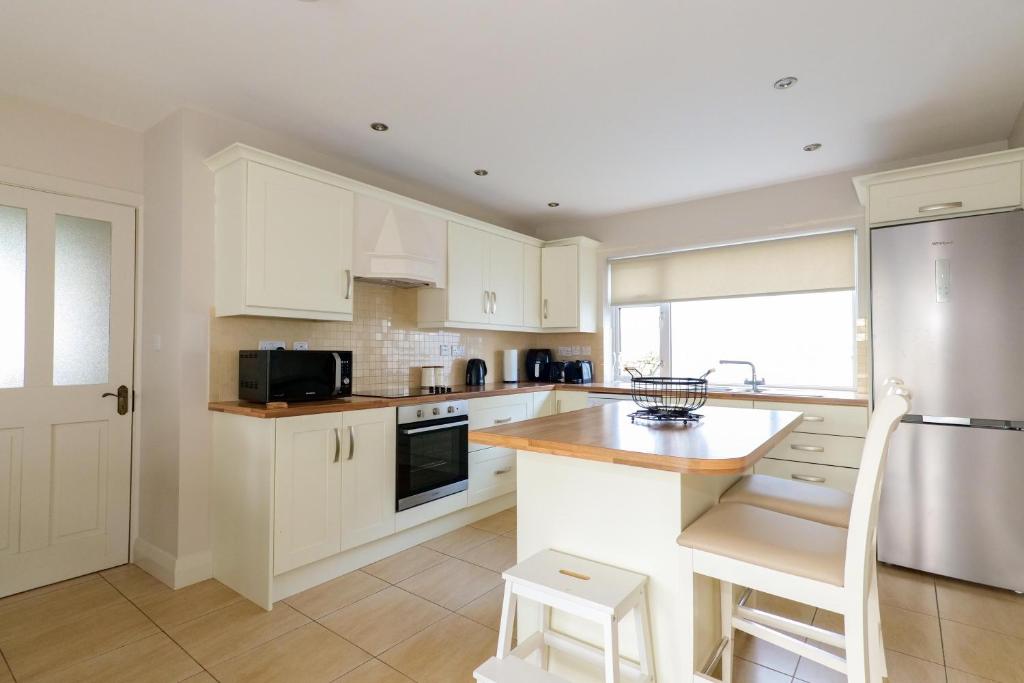 a kitchen with white cabinets and a counter top at Cozy Connemara Family Retreat in Derroogh