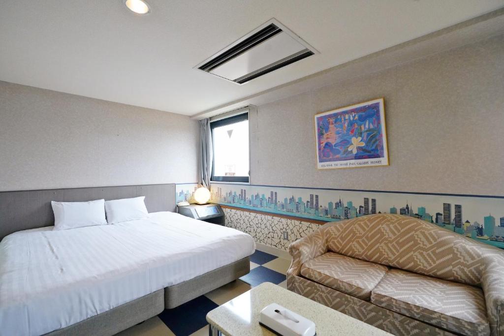 a hotel room with a bed and a couch at ホテル韮崎インター in Nirasaki