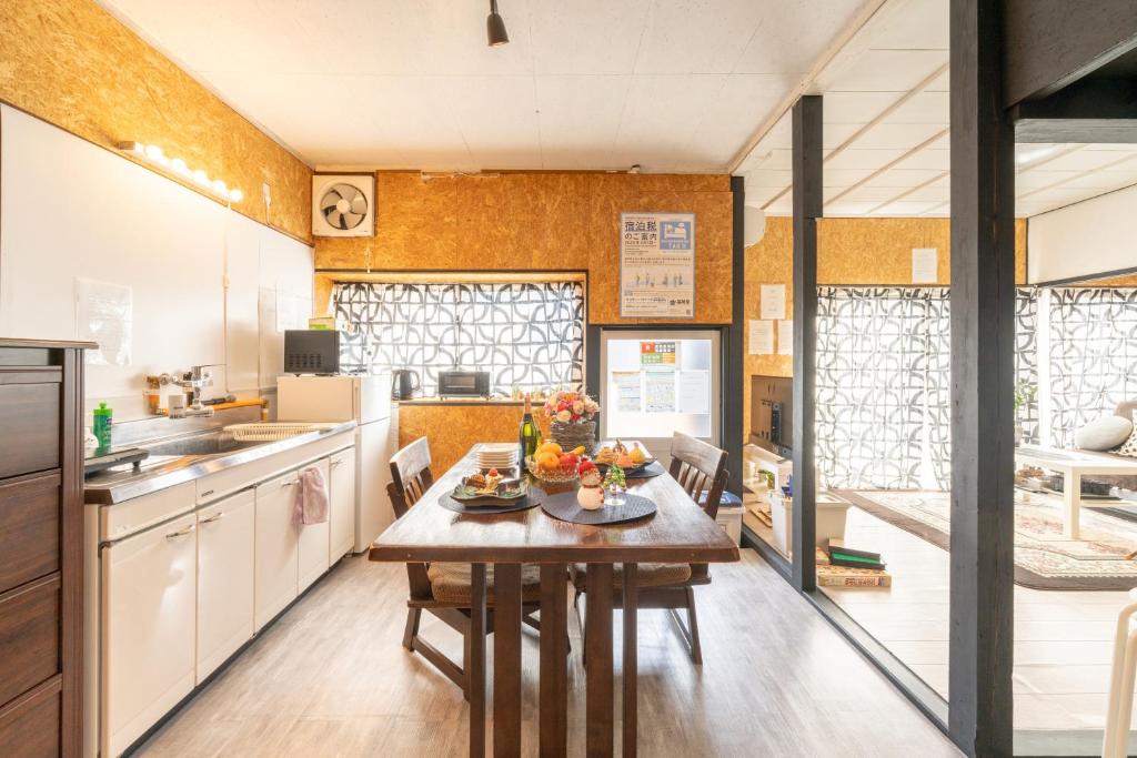 a kitchen with a wooden table in a room at Jupiter 糸島市1棟貸し切り宿 in Itoshima
