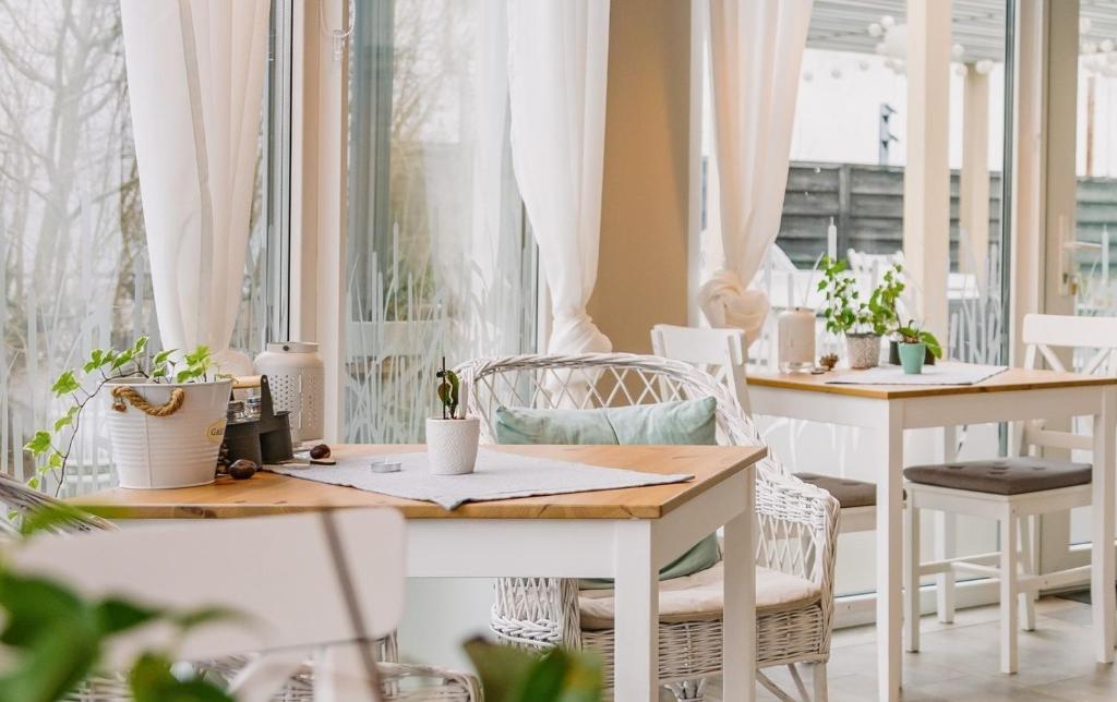 ein Tisch und Stühle in einem Zimmer mit Fenstern in der Unterkunft Pihi Vendégház in Badacsonytomaj
