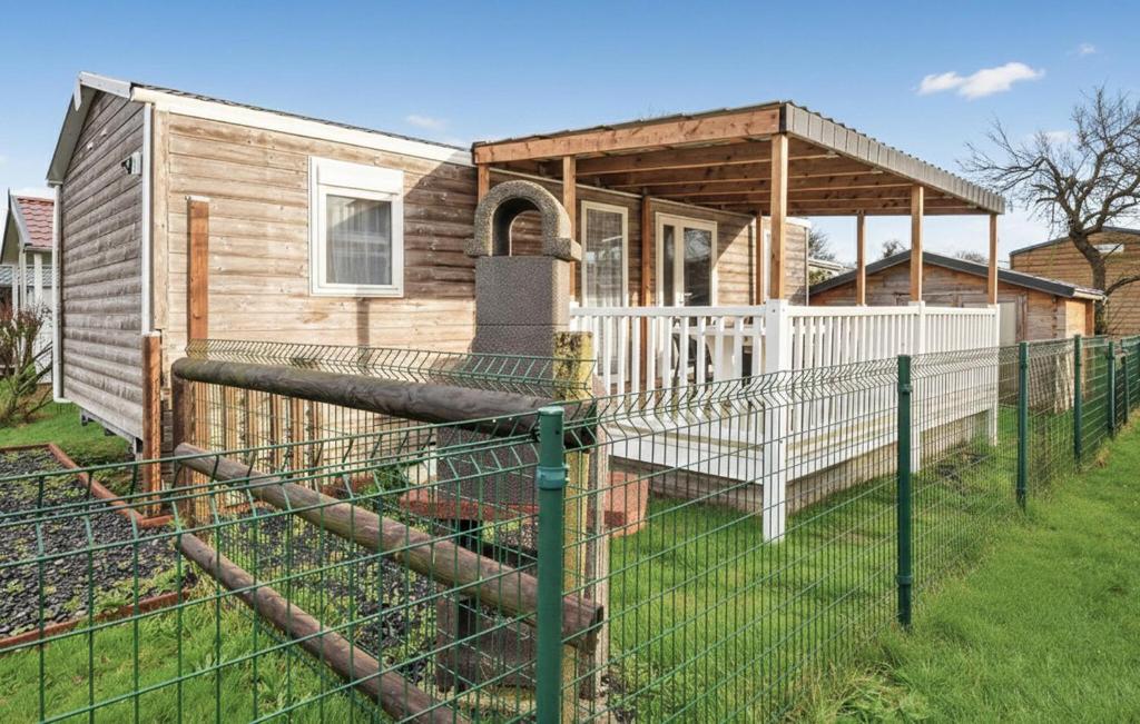 a house with a fence in front of it at Mobile-Home Proche Mer 400M in Grandcamp-Maisy