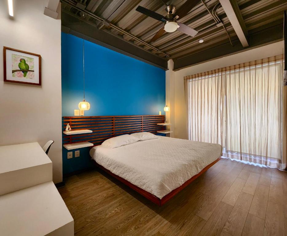 a bedroom with a bed and a blue wall at Torre Yaxche Urban Center in Cancún