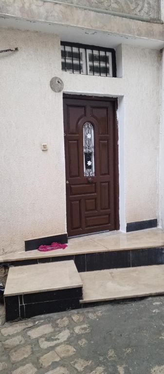a brown door on the side of a building at Maison de vacance in Bin Rhilouf