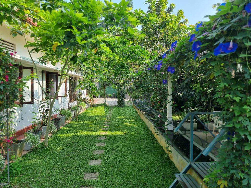 a garden with green grass and trees and plants at Mahaweli Shades in Kandy