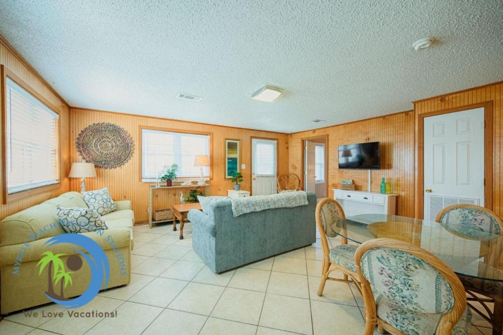a living room with a couch and a table at Cg Beach Bungalow #1 in Myrtle Beach