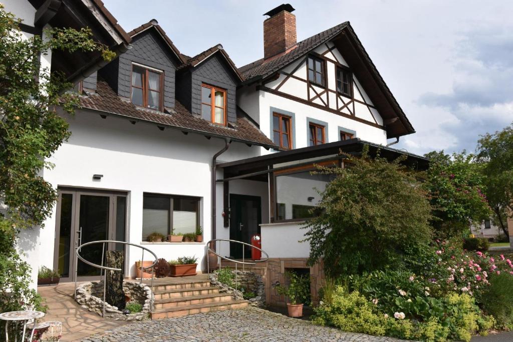 a white house with a black roof at Hammonds Jura Ferienwohnungen in Kasendorf