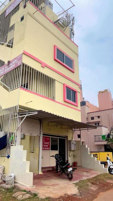 a building with a motorcycle parked in front of it at ISIRI Rooms in Mysore