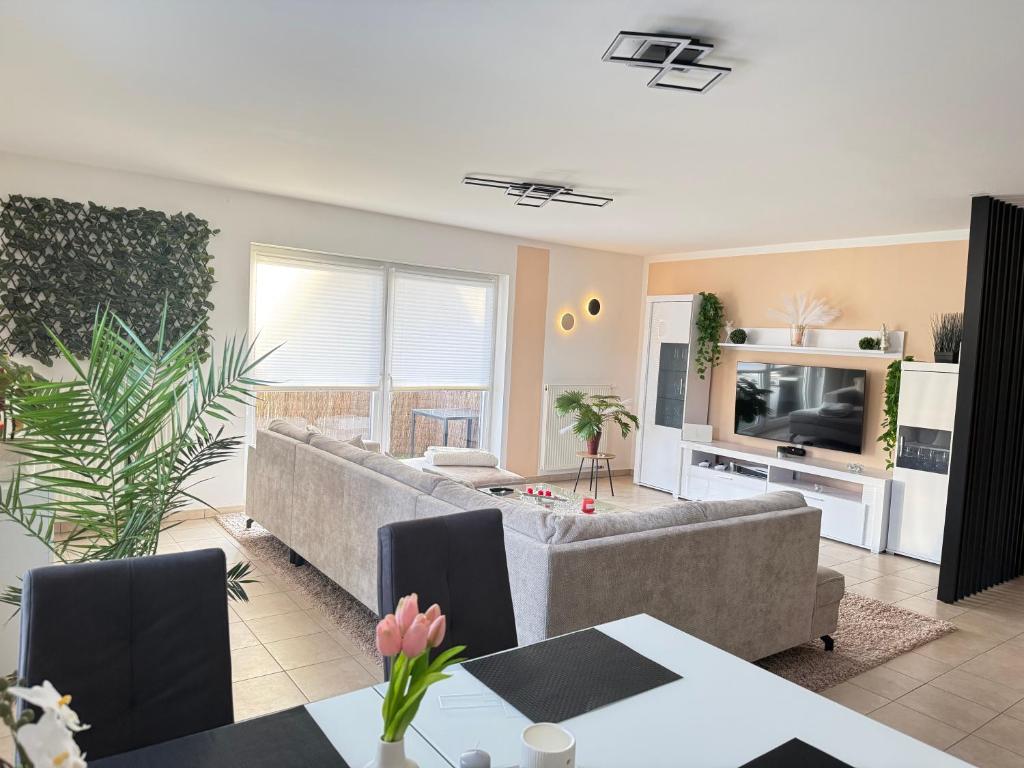 a living room with a couch and a tv at Modernes Apartment in Orscholz in Mettlach