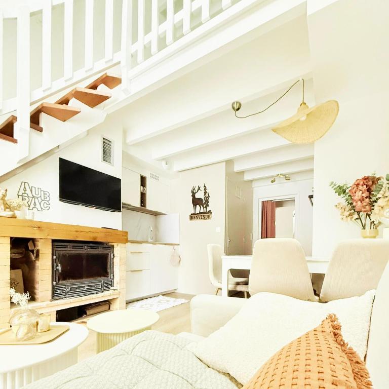 a living room with white furniture and a fireplace at Chalet Le Reposou in Laguiole