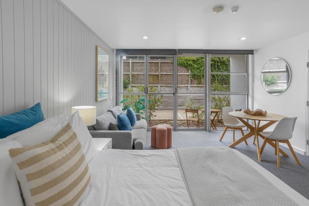a bedroom with a bed and a living room at Bay View Style in Lorne
