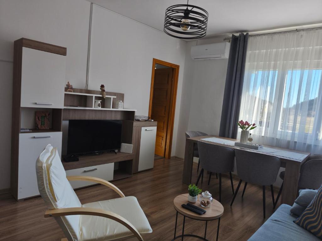 a living room with a couch and a table with chairs at Apartman Ane in Perušić