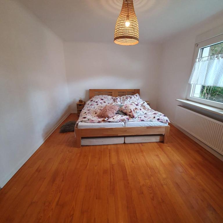 a bedroom with a bed in a room with wooden floors at Ferienhaus Meiers in Losheim