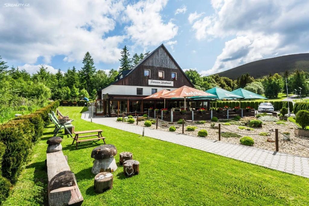 a large barn with benches and tables in the grass at Penzion Neubauer in Ostružná