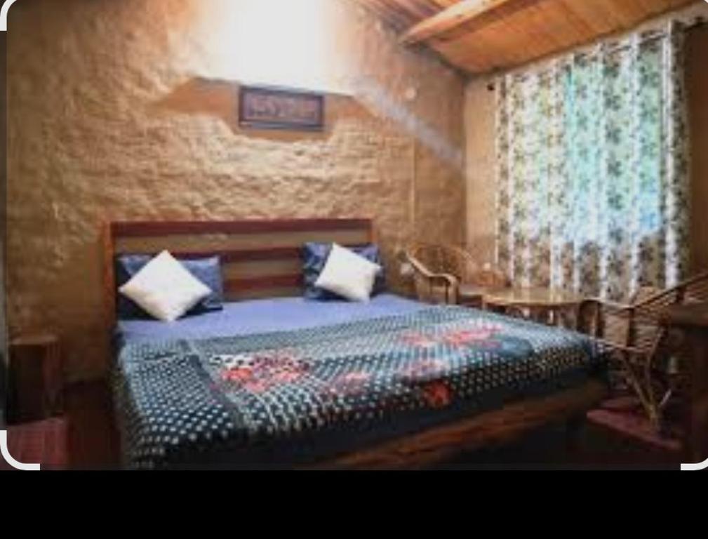 a bedroom with a bed and a table and a window at Hidden paradise homestay in Rongli
