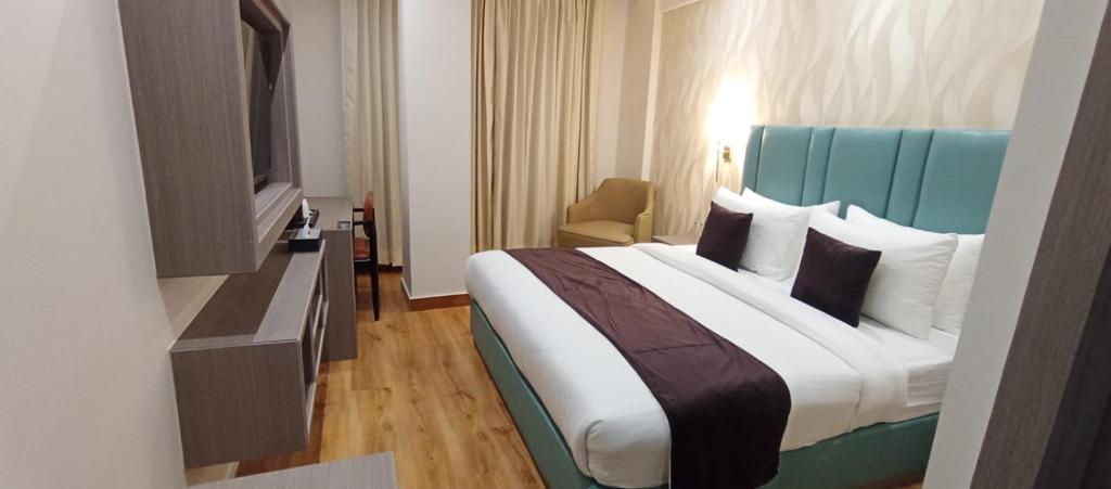 a hotel room with a large bed and a television at Aair Hotel And Resorts in Karnal