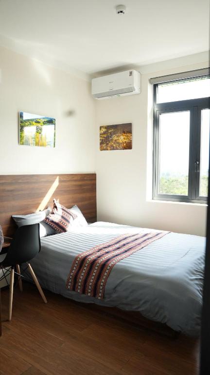 a bedroom with a bed and a desk and a window at XƠ ĐĂNG homestay in Kon Plong