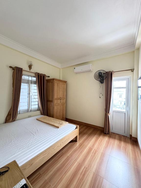 a bedroom with a bed in a room with wooden floors at Hương Dịu Hotel đảo Quan Lạn in Quan Lạn