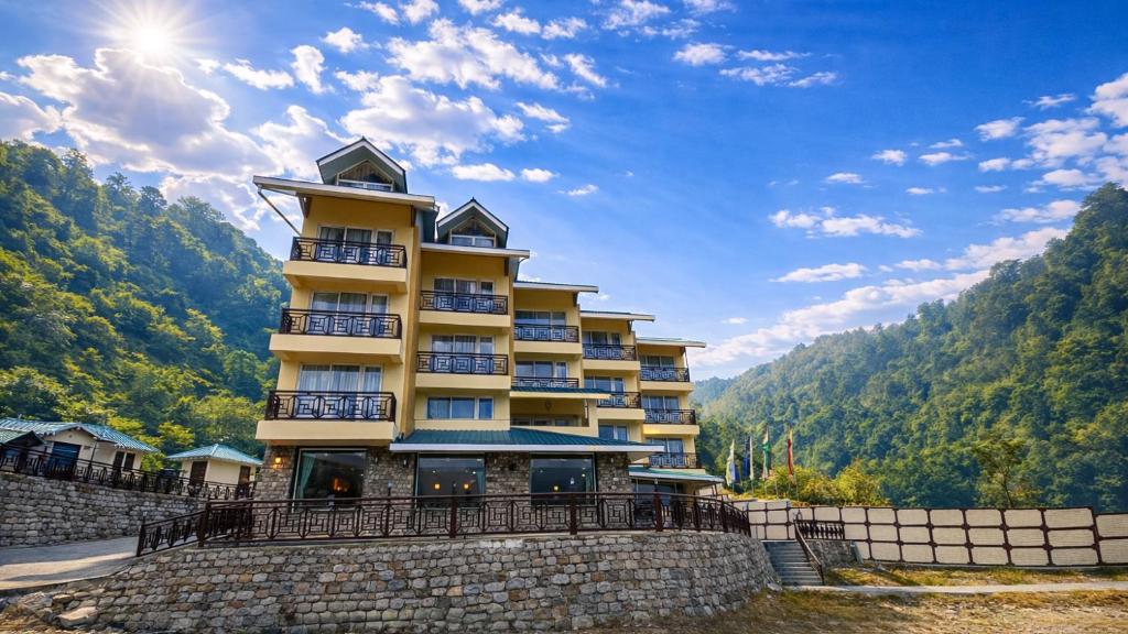 a building on top of a stone wall at Yashshree Dewathang Resort in Lachung