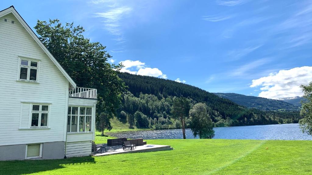 a white house with a view of a lake at Lake House in Vossevangen