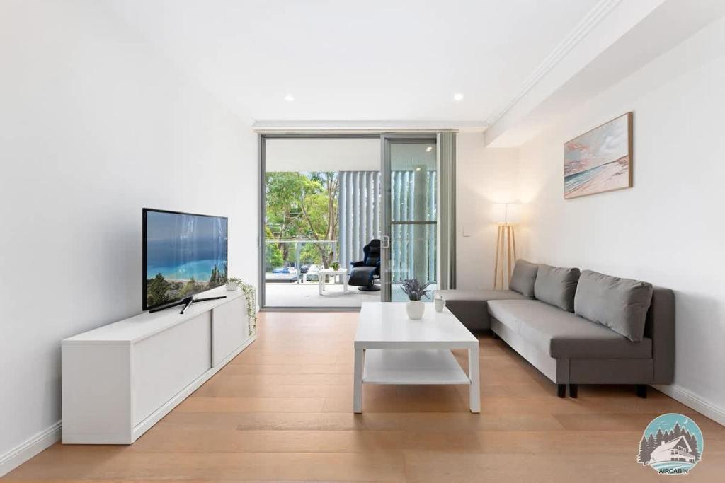 a living room with a couch and a tv at Epping 2BR House with Parking in Epping