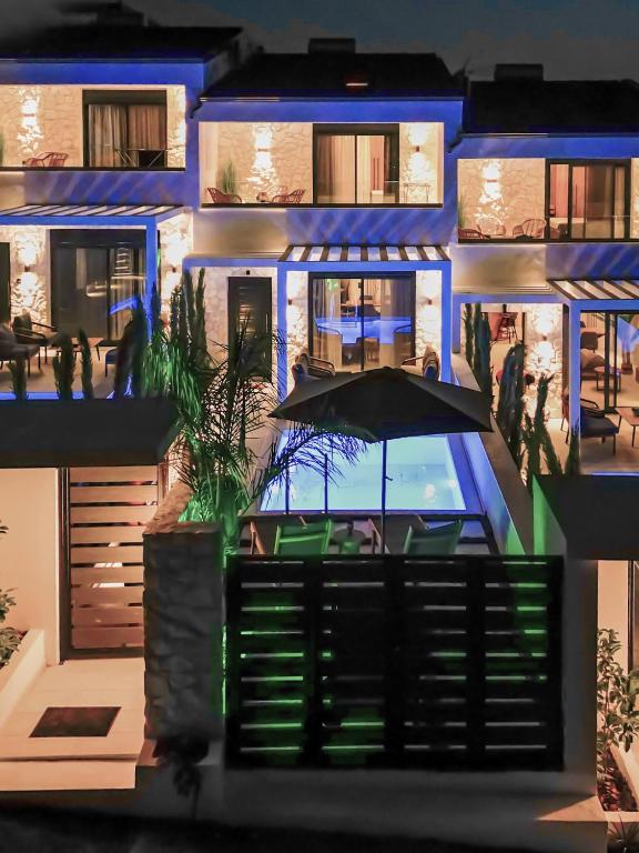 a blue building with a swimming pool and an umbrella at Kara Villas in Kallithea Halkidikis
