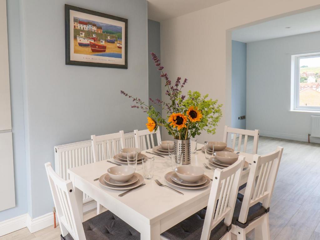 a white dining room with a white table and chairs at Whitby View in Whitby