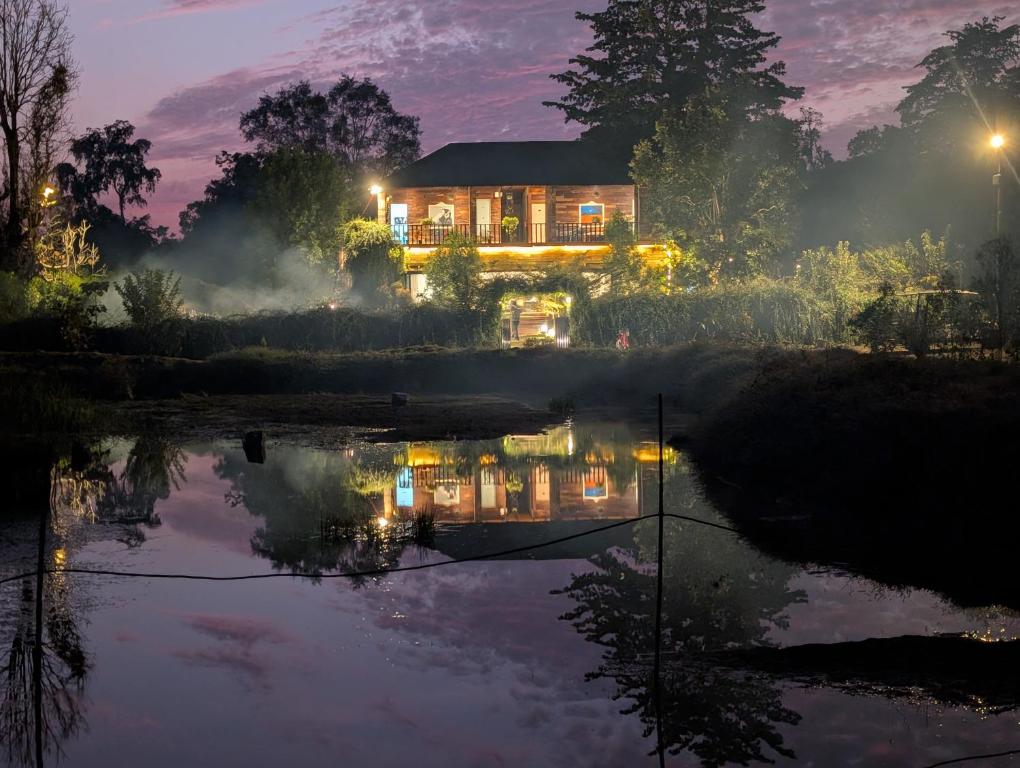 a house in the middle of a pond at night at Jewel Stay in Tāla
