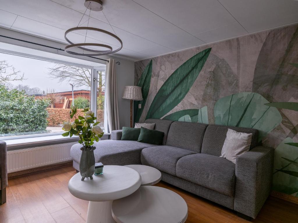 a living room with a couch and a large window at Ermrest Cottage in Erm