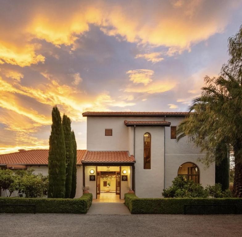 a house with a sunset in the background at El Grouso in Blenheim